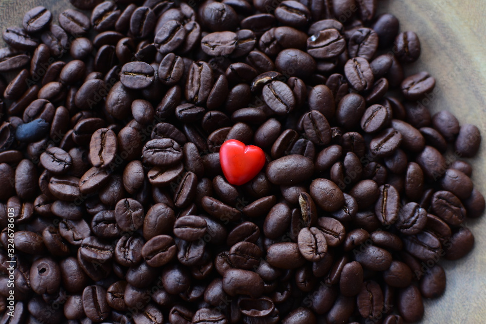 Processed coffee beans and tostao, with red heart on wooden background Processed coffee beans and tostao, with red heart on wooden background