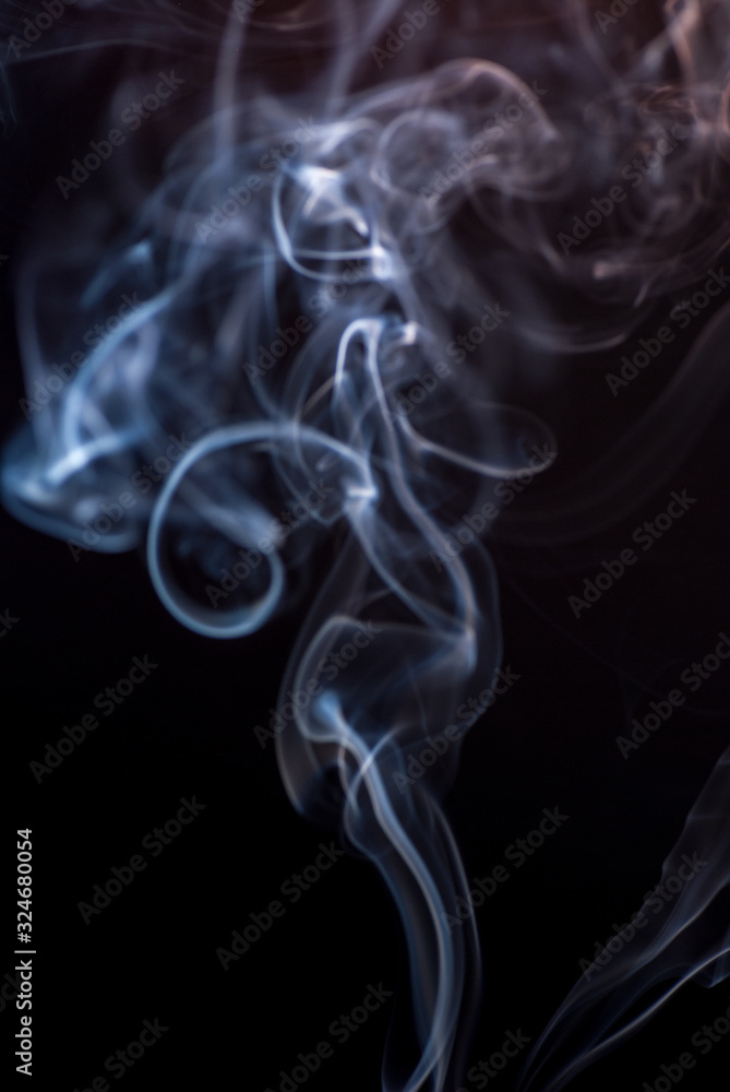 Beautiful smoke on the black background - macro photo. The concept of incense in the apartment. Isolated on black background overlay for your needs