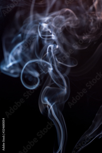 Beautiful smoke on the black background - macro photo. The concept of incense in the apartment. Isolated on black background overlay for your needs