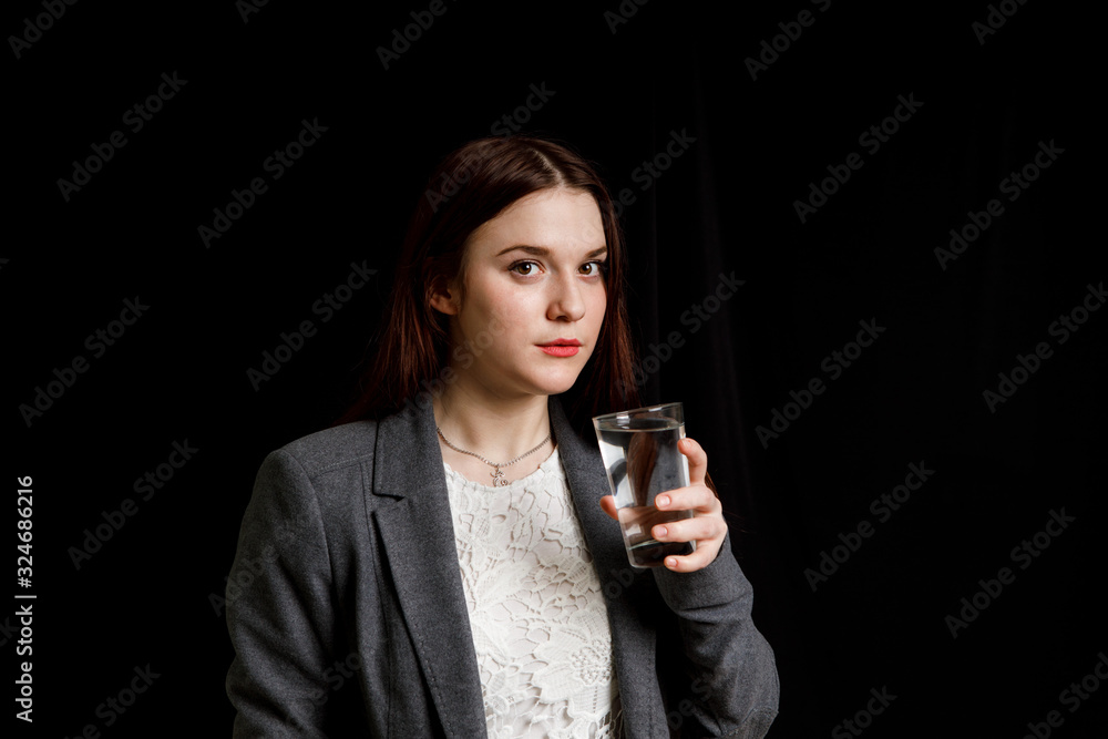 Portrait of a woman drinking water. Smiling girl. Portrait on a black background Portrait of a woman drinking water. Smiling girl. Portrait on a black background
