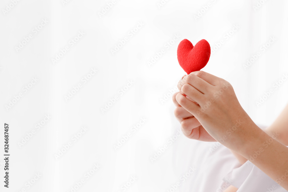Close up woman's hand holding red heart with copy space on left side. Close up woman's hand holding red heart with copy space on left side.