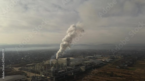 Drone flying over smoking smokestacks of a сhipboard factory. Smoke coming from the chimneys of the plant. Air pollution concept photo