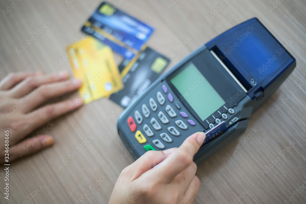 The store staff is swiping a credit card to pay for the product. Concept of payment using a debit card. The store staff is swiping a credit card to pay for the product. Concept of payment using a debit card.