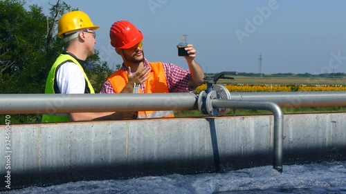 Engineers controlling a quality of water ,aerated activated sludge tank at a waste water treatment plant       