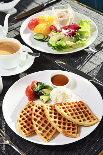 Waffles with fresh fruit and cream for breakfast on the plate