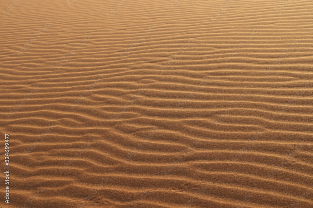 sand texture - background of desert sand dunes. Beautiful structures of sandy dunes. sand with wave from wind in desert - Close up sand texture - background of desert sand dunes. Beautiful structures of sandy dunes. sand with wave from wind in desert - Close up