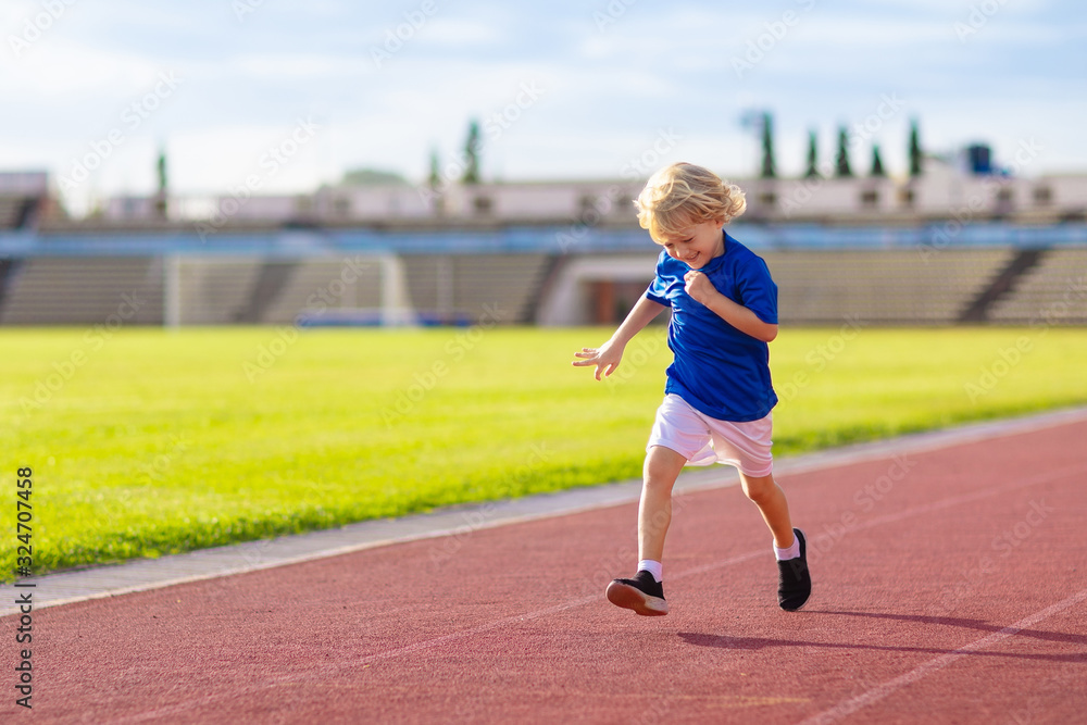 Fototapeta premium Child running in stadium. Kids run. Healthy sport.