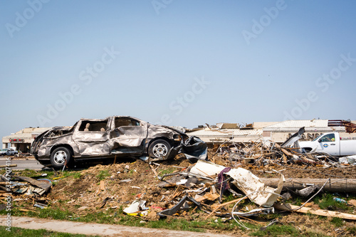 Tornado Storm Damage with battered cars and broken buildings