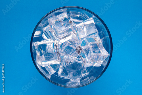 Regular scotch glass with crystal Ice cubes on a blue background