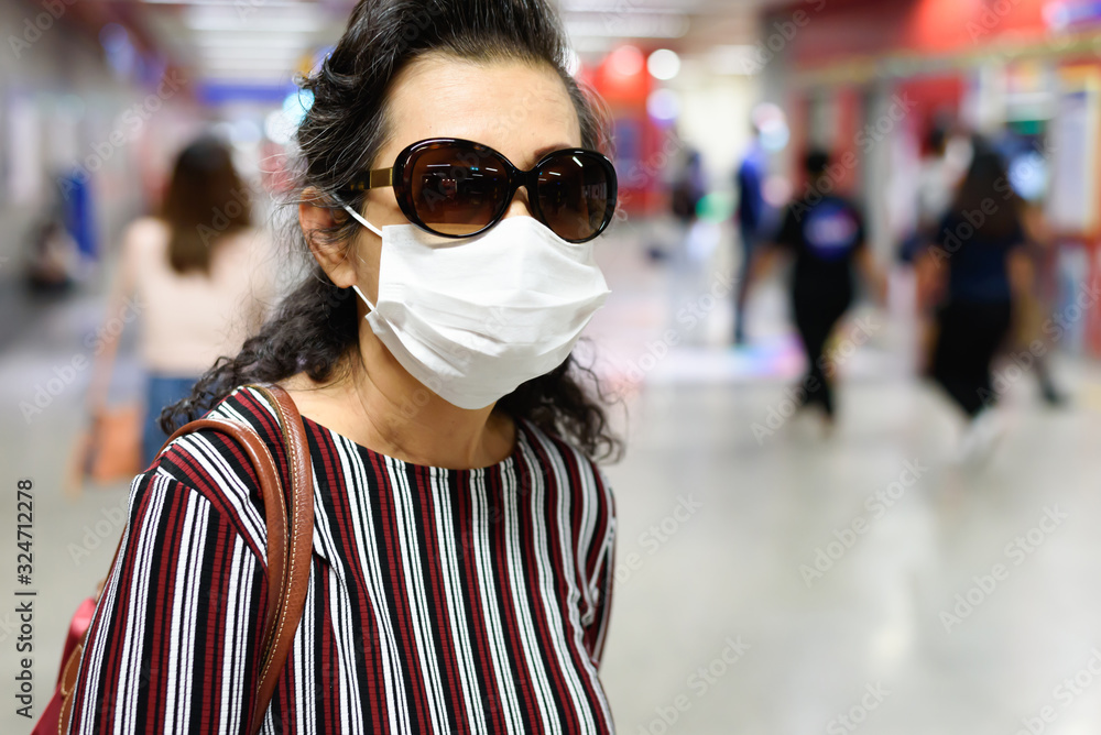 Old woman wearing a face mask and sunglasses Old woman wearing a face mask and sunglasses