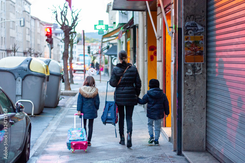 Madre con niños de camino al colegio photo