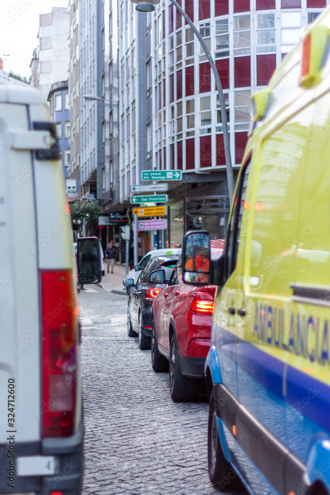 Calle antigua con ambulancia y coches detenidos en semáforo Calle antigua con ambulancia y coches detenidos en semáforo