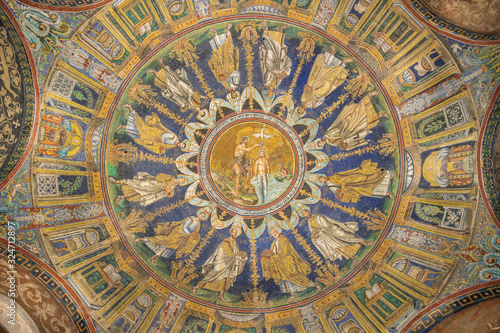RAVENNA, ITALY - JANUARY 28, 2020: The ceiling symbolic mosaic with Baptism of Christ in the center among the apostles in  Baptistery of Neon (Battistero Neoniano from 5. cent.
