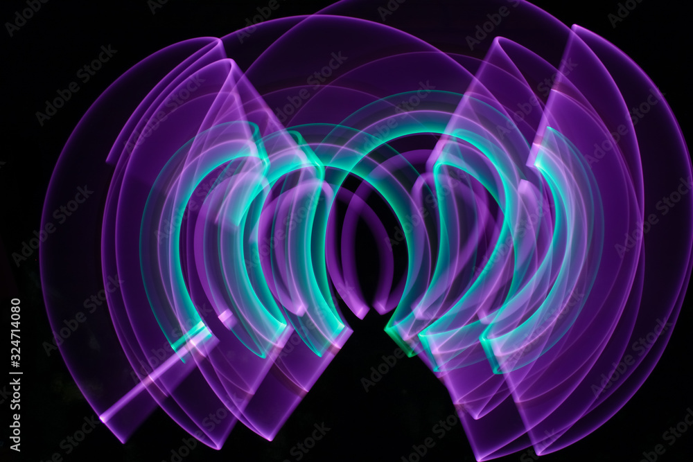 Obraz premium Curved abstract shape made with a light saber violet. Lightpainting session at night. Leds light effect. Background for wallpaper.