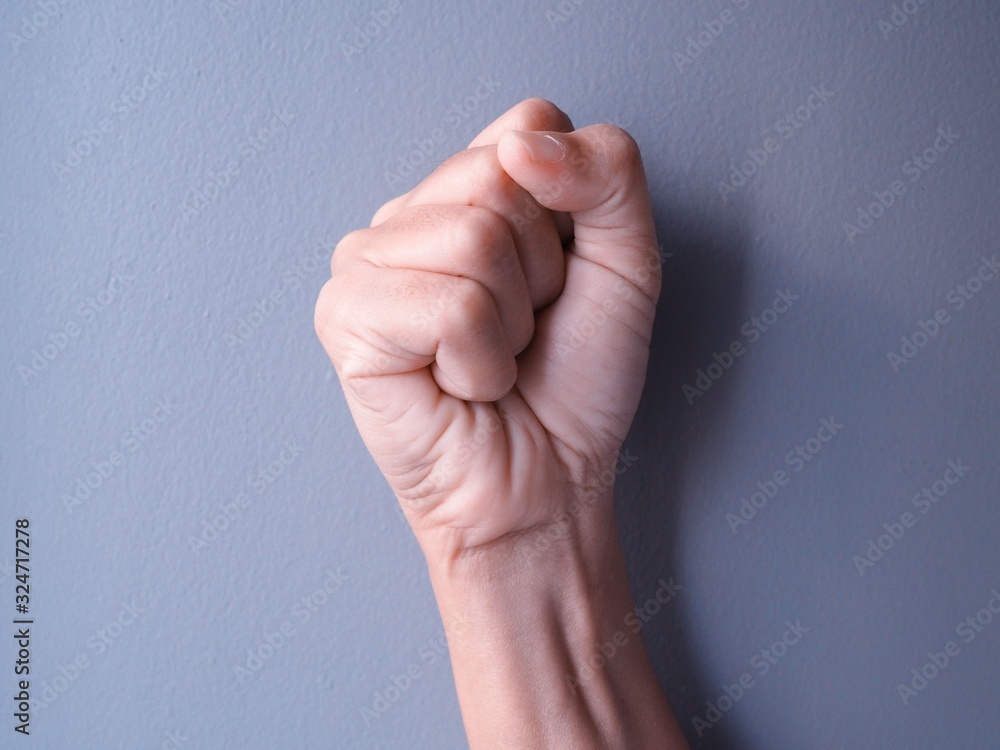 hand clenched fist, isolated on gray wall background. hand clenched fist, isolated on gray wall background.
