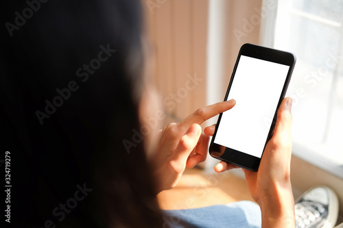 Cropped shot view of woman hands holding smart phone with blank copy space screen for your text message or information content, female reading text message on cell telephone during in urban setting.