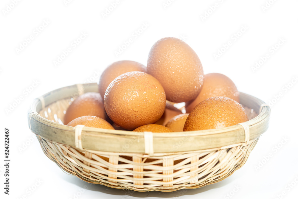 Fresh eggs with water condensation in a rattan basket. Isolated on white. Shallow depth of field. Fresh eggs with water condensation in a rattan basket. Isolated on white. Shallow depth of field.