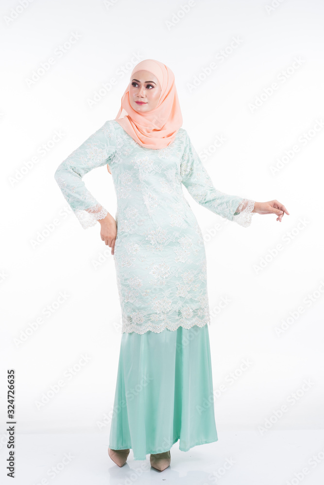 Beautiful female model in modern kurung and hijab, a modern lifestyle apparel for Muslim women isolated on white background. Beauty and hijab fashion concept. Full length portrait Beautiful female model in modern kurung and hijab, a modern lifestyle apparel for Muslim women isolated on white background. Beauty and hijab fashion concept. Full length portrait