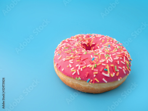 pink doughnut with sweet topping on a blue background close-up