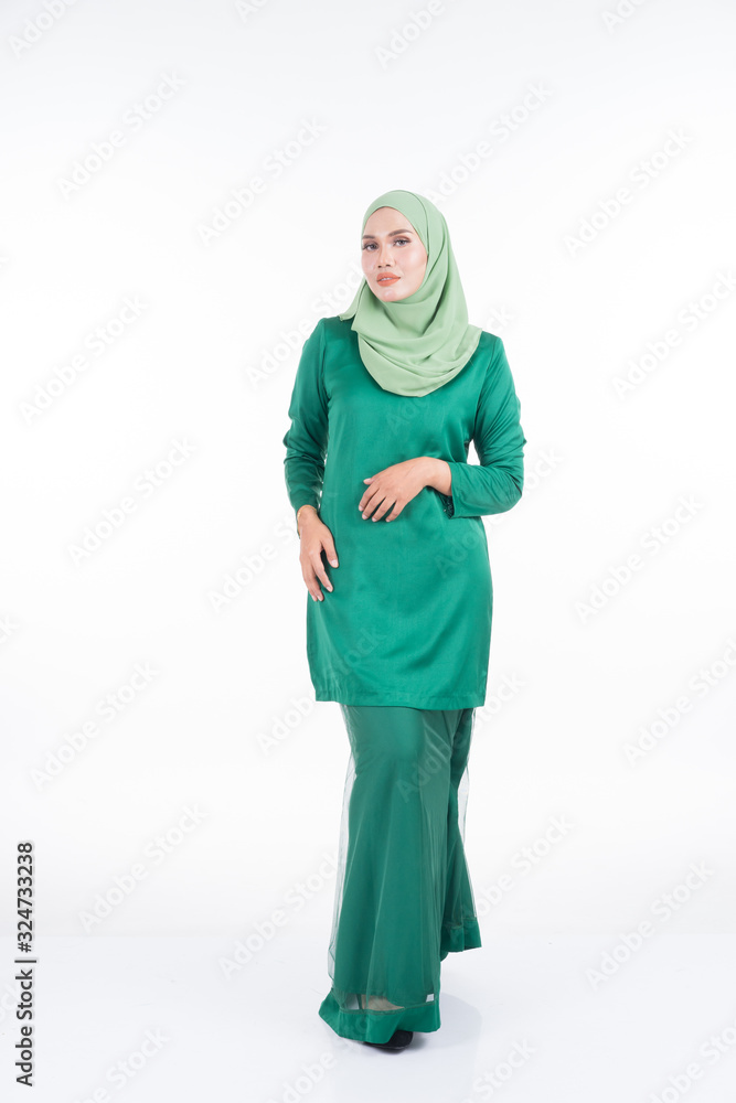 Beautiful female model in modern kurung and hijab, a modern lifestyle apparel for Muslim women isolated on white background. Beauty and hijab fashion concept. Full length portrait Beautiful female model in modern kurung and hijab, a modern lifestyle apparel for Muslim women isolated on white background. Beauty and hijab fashion concept. Full length portrait