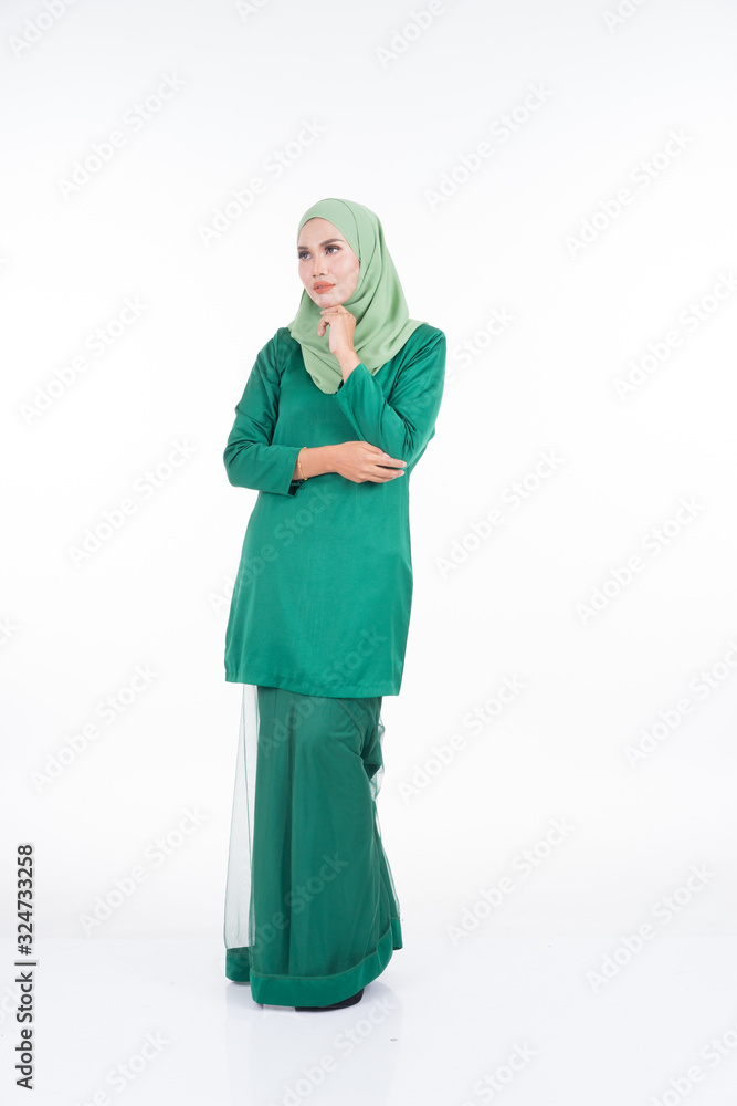 Beautiful female model in modern kurung and hijab, a modern lifestyle apparel for Muslim women isolated on white background. Beauty and hijab fashion concept. Full length portrait Beautiful female model in modern kurung and hijab, a modern lifestyle apparel for Muslim women isolated on white background. Beauty and hijab fashion concept. Full length portrait
