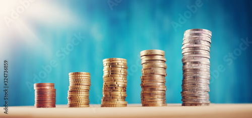 stacked coins on blue background. Money columns photo