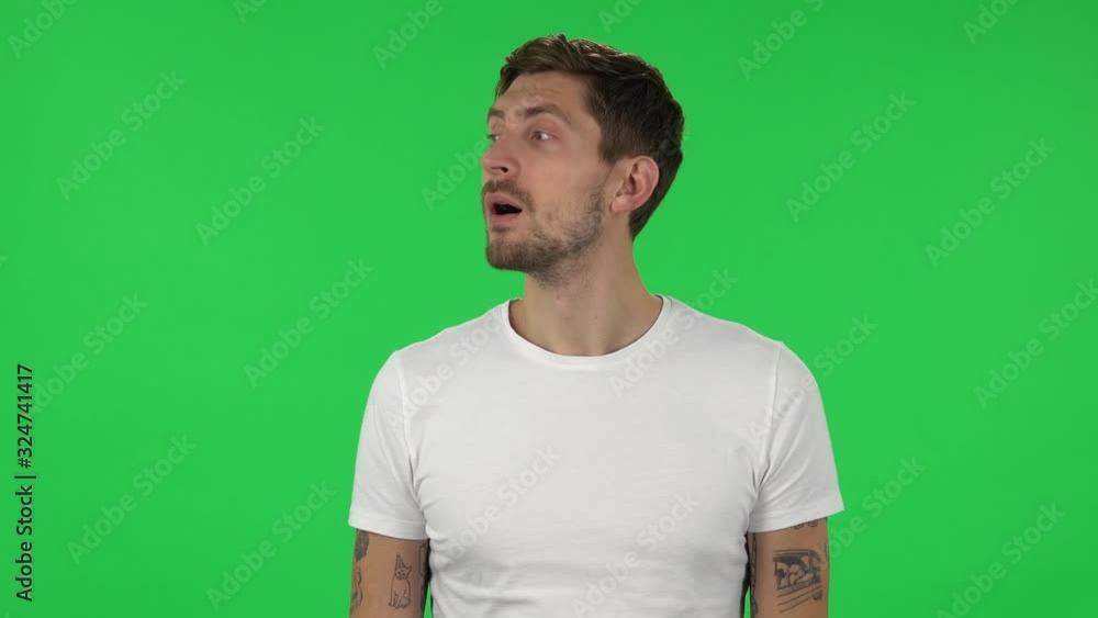 Portrait of confident guy is shocked at what is happening around, looking with delight and admiration. Green screen Portrait of confident guy is shocked at what is happening around, looking with delight and admiration. Green screen