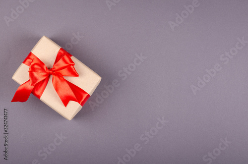 Gift box on dark background composition, present with ribbon and bow.