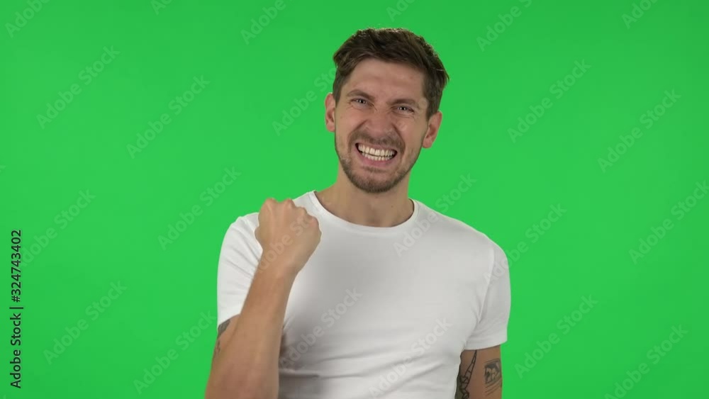 Portrait of confident guy is looking at the camera with excitement, then celebrating his victory triumph. Green screen Portrait of confident guy is looking at the camera with excitement, then celebrating his victory triumph. Green screen