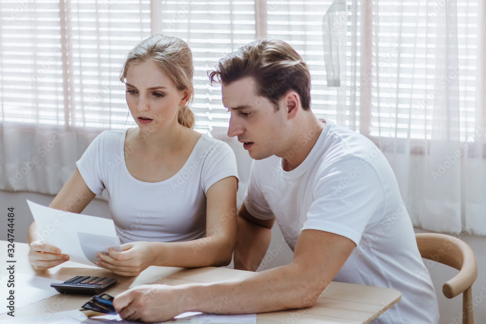 Obraz premium Stressed caucacian couple conflict of credit card bills or debt of over expense in shopping. Lover financial risk or crisis and bad habits of shopaholic. Lack of money discipline, planning and advisor
