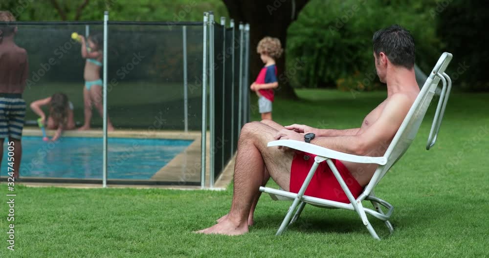 Kid In Pool With Parent Lifeguard parent observing children play at the swimming pool in ...