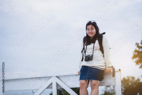 Asian women traveling alone with backpack and camera.Travel Holiday Relaxation Concept , Vintage Style. © EsanIndyStudios