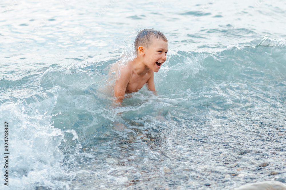 little girl in a swimsuit splashing her legs in the sea