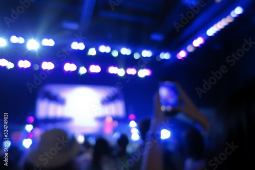 Blurred of concert lighting with joyful people. Abstract background concept.
