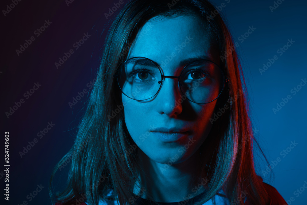 Close up portrait of a young serious woman wearing round eye gla Close up portrait of a young serious woman wearing round eye gla