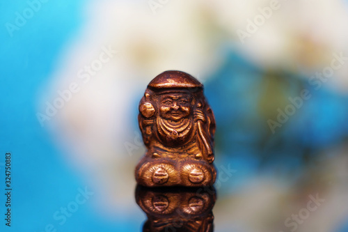 Ancient Netsuke The Japanese god of fortune and wealth Daikokuten. Daikoku is one of the seven gods of fortune. Macro soft focus photo