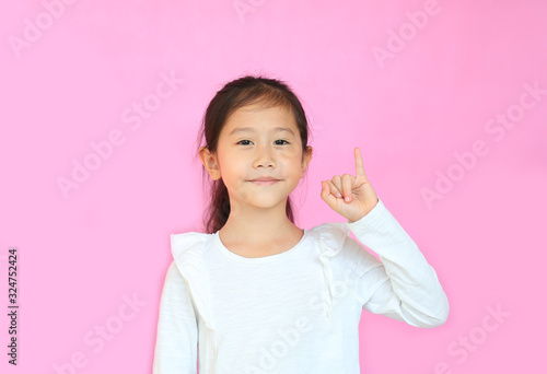 Fotografie Beautiful asian little girl showing pinkie finger isolated on pink background