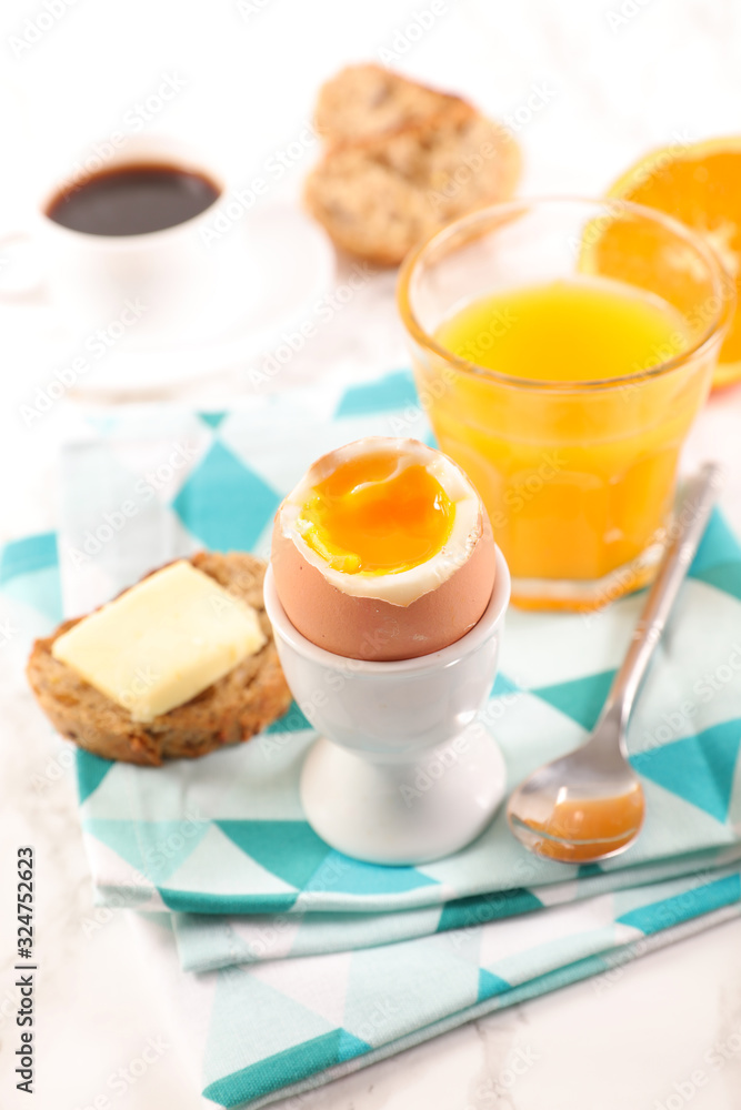 Fototapeta premium boiled egg, toast with butter, coffee cup and orange juice