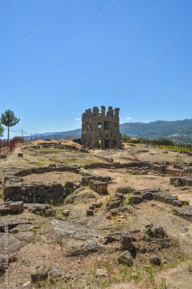 View at the exterior front facade of medieval Saint Cornélio tower, woman looking the building, iconic ruins monument building at the Belmonte village, portuguese patrimony