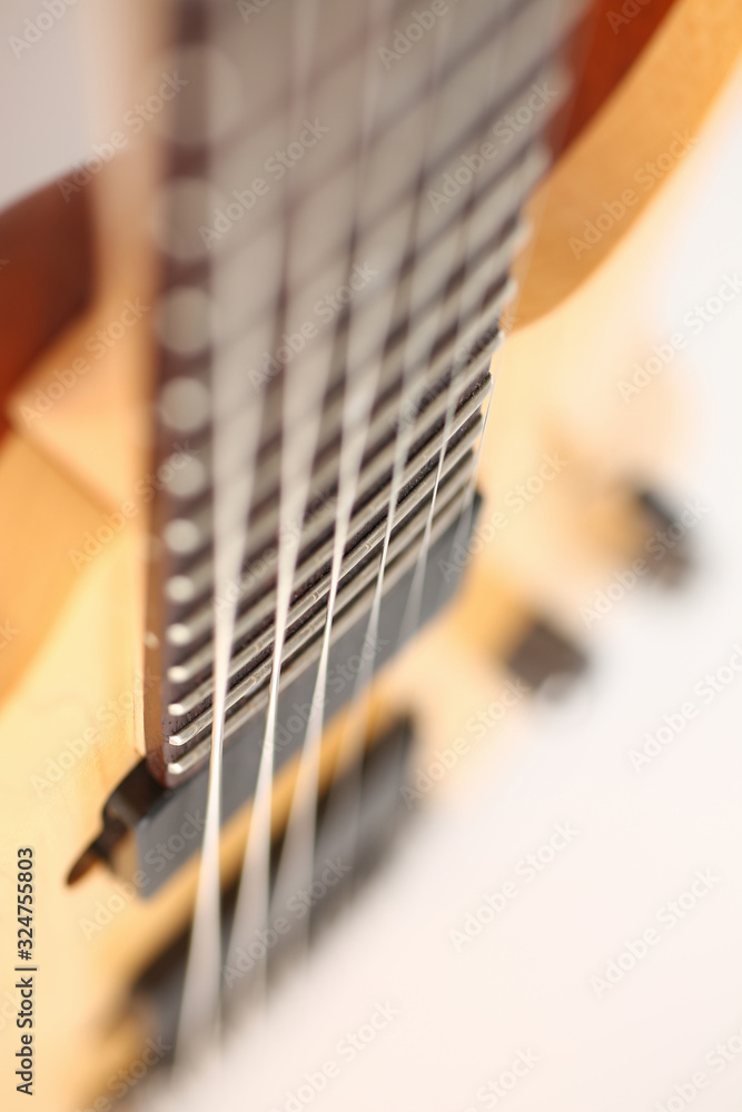 Fototapeta premium Classic shape wooden electric guitar with rosewood neck closeup. Six stringed learning lesson musician school education art leisure electrical vintage stage wood guitar concept