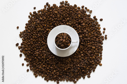 white cup on coffee beans on a white background, top view
