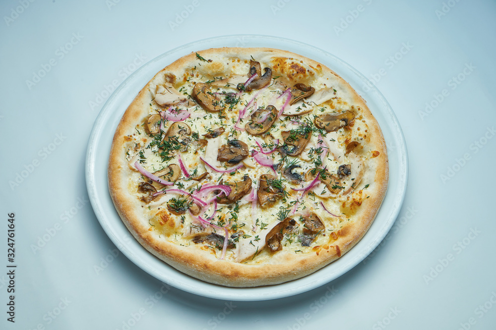 Appetizing baked Italian pizza with cream sauce, onions and mushrooms on a white plate isolated on gray background Appetizing baked Italian pizza with cream sauce, onions and mushrooms on a white plate isolated on gray background