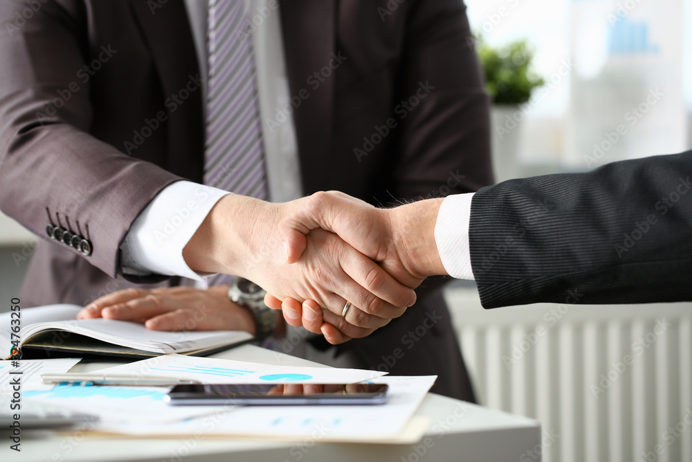 Man in suit shake hand as hello in office closeup. Friend welcome mediation offer positive introduction greet or thanks gesture summit participate approval motivation strike arm bargain concept Man in suit shake hand as hello in office closeup. Friend welcome mediation offer positive introduction greet or thanks gesture summit participate approval motivation strike arm bargain concept