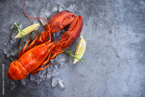 Fresh lobster food on a black plate background - red lobster dinner seafood with herb spices lemon rosemary served table and ice in the restaurant gourmet food healthy boiled lobster cooked photo