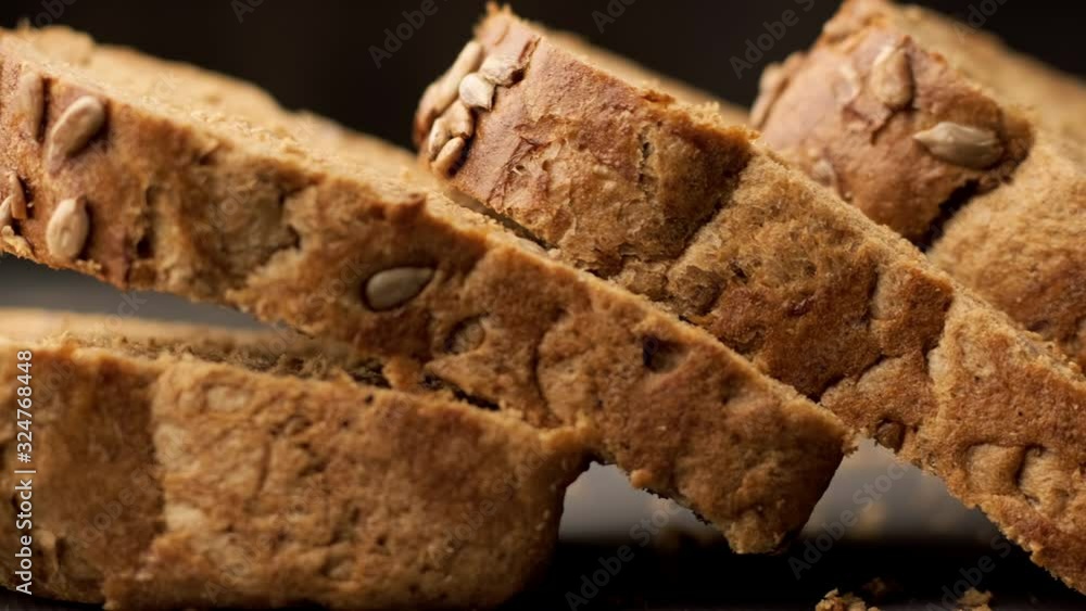 Cutted slices of bread. Close-up view of brown organic bread. Panning shot in 4K, UHD Cutted slices of bread. Close-up view of brown organic bread. Panning shot in 4K, UHD