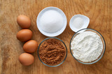 Ingredients for making chocolate cake on old wooden background