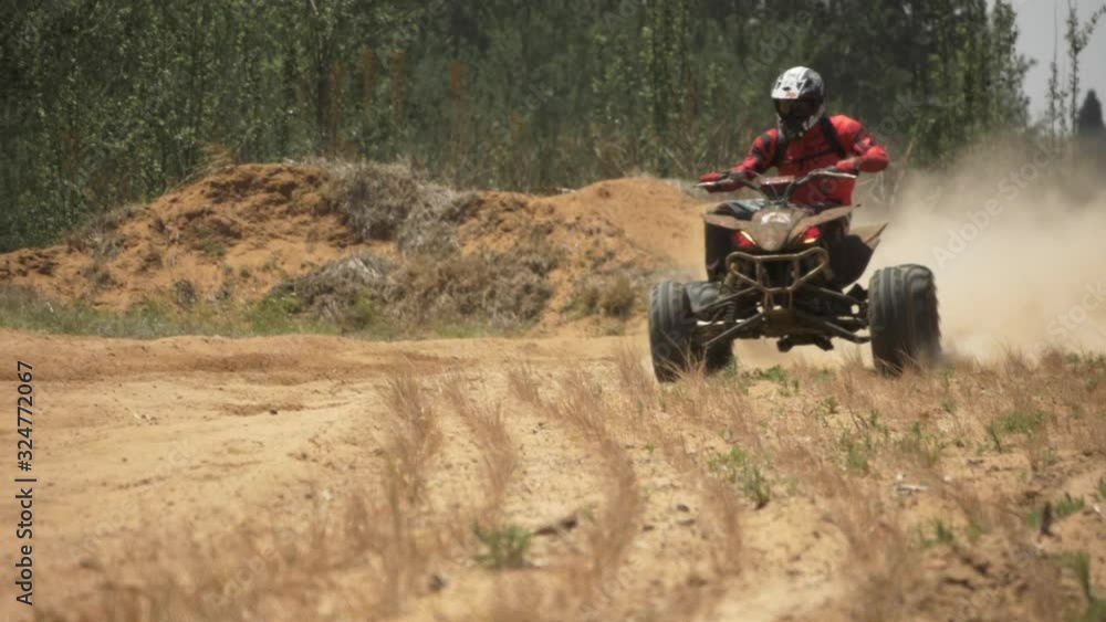 Quad-biker sliding into a corner at a race. (slow-motion) Quad-biker sliding into a corner at a race. (slow-motion)