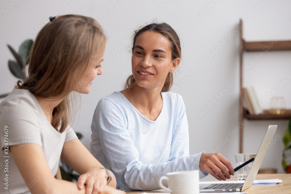 Smiling businesswoman with colleague working on project together Smiling businesswoman with colleague working on project together
