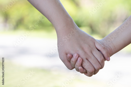 Mother holding a hand of child in garden. Using for family,safety and lead concept. © nong
