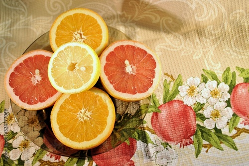 Fototapeta Naklejka Na Ścianę i Meble -  Fresh organic ripe fruits orange grapefruit lemon natural gourmet product brown plate red white background